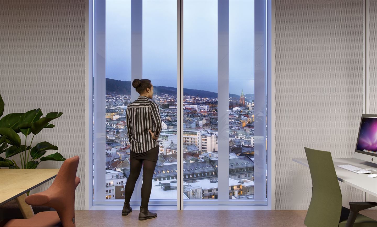 dame som kikker på Utsikt frå Vestlandshuset gjennom stort vindu i kontorlandskap