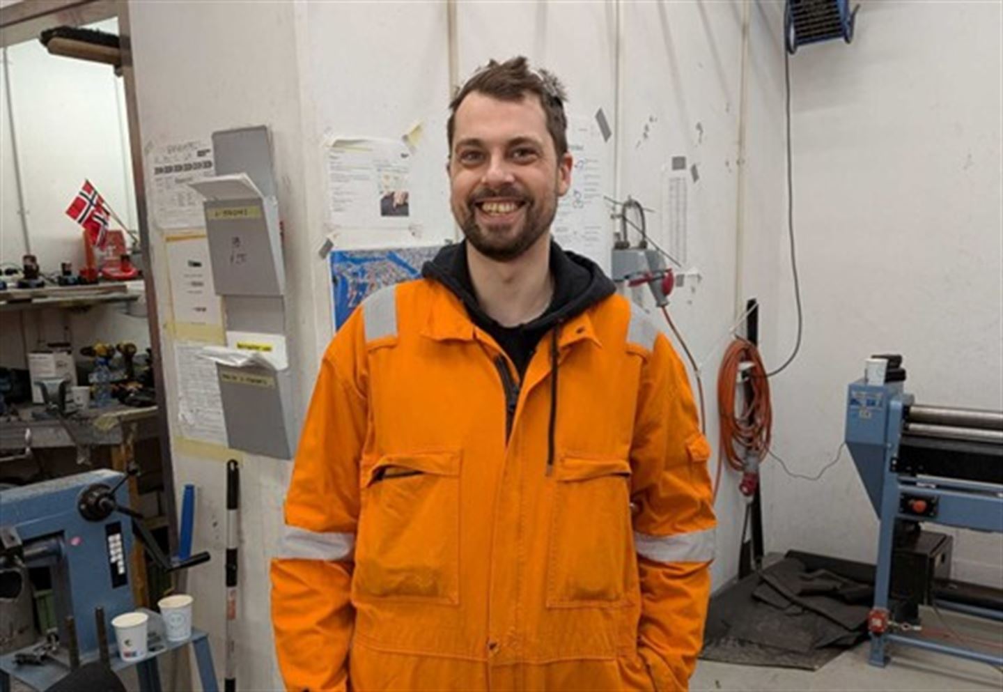 Smilende mann i oransje arbeidsklær