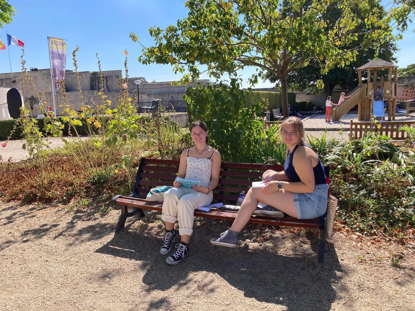 To jenter sitt på ein benk.