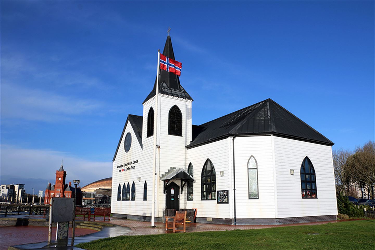 Kirke med norsk flagg på flaggstanga. 