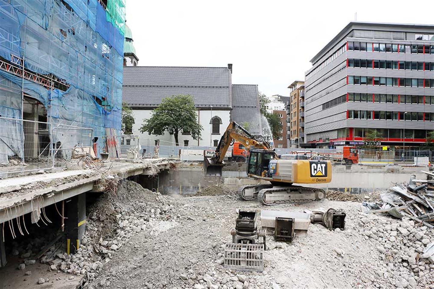 Ein gravemaskin er i ferd med å rigge til for at den største rivemaskinen i sitt slag i Noreg, skal få plass for å fjerne resten av fylkeshuset.