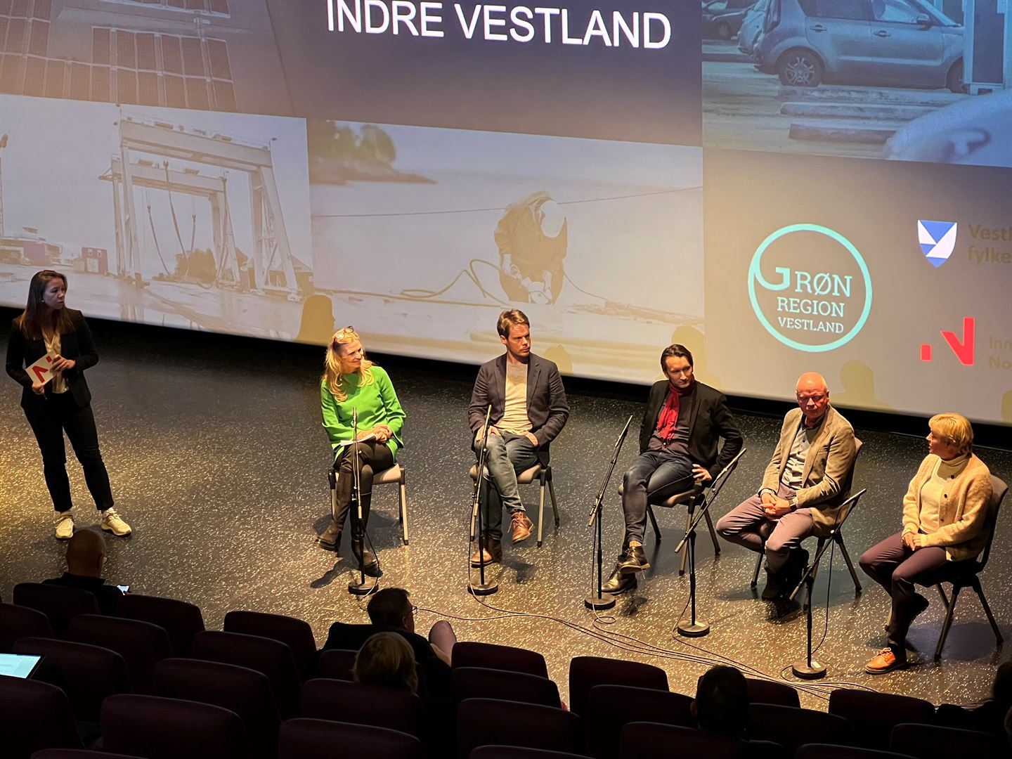 5 personar sitt med avstand til kvarandre på rad på ei scene.