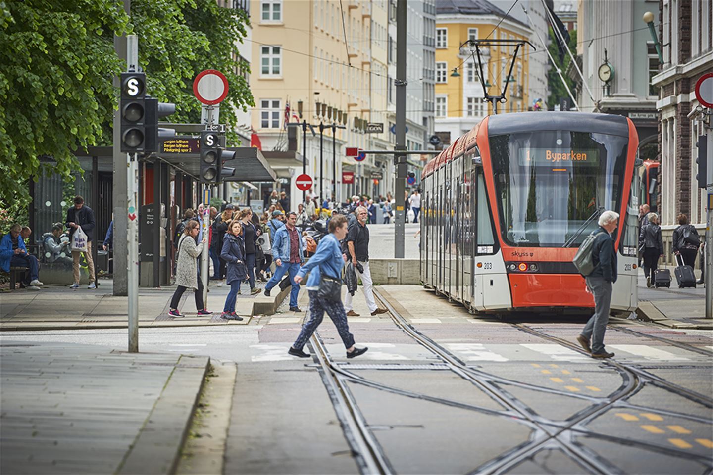 Foto av bybanen og mange gåande i Bergen sentrum.