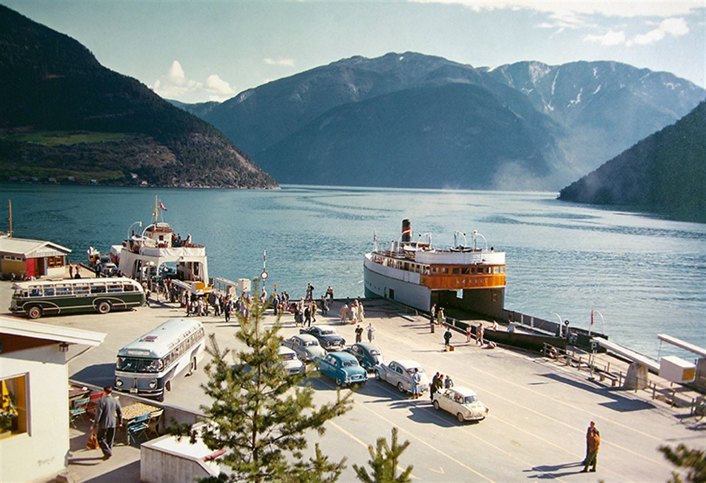 gamalt foto frå ferjekaien på Kaupanger, med ferje til kai og bilar og bussar på kaien.