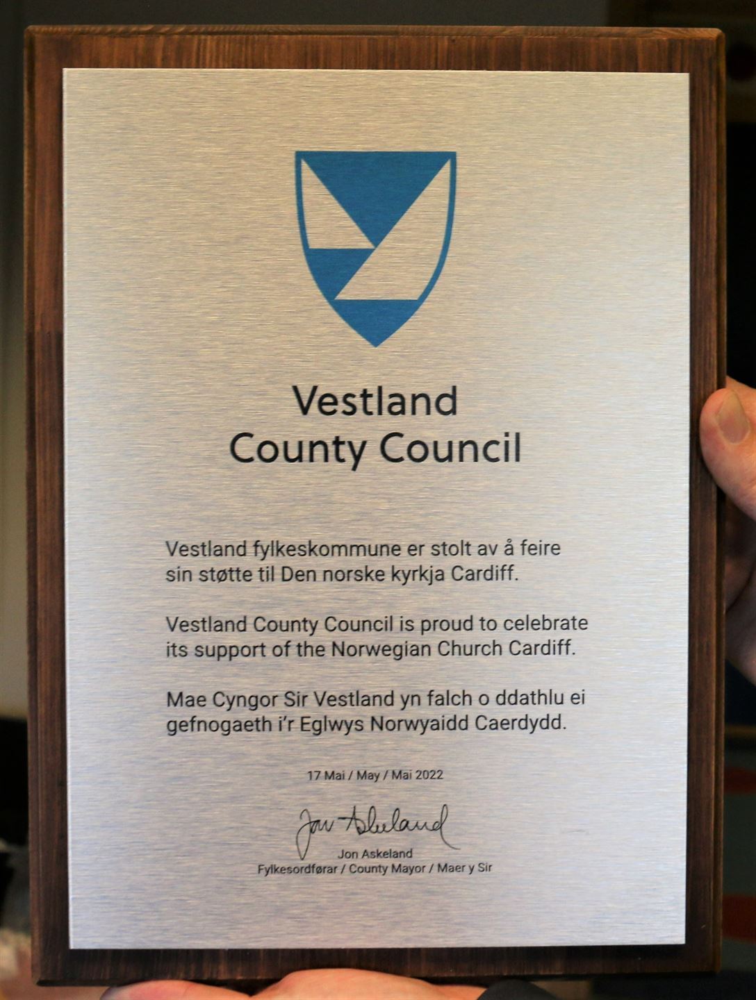 Plakett med teksten: Vestland fylkeskommune er stolt av å feire sin støtte til Den norske kyrkja Cardiff. Foto.
