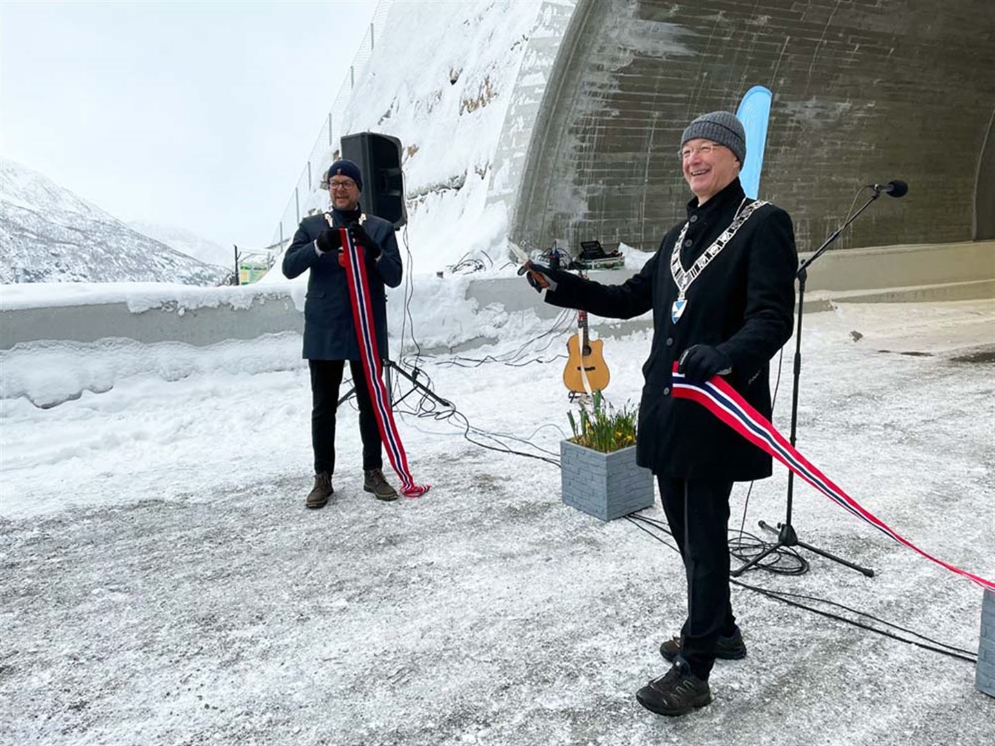 Hilmar Høl og Jon Askeland klypper snora framfor tunellen. Foto.