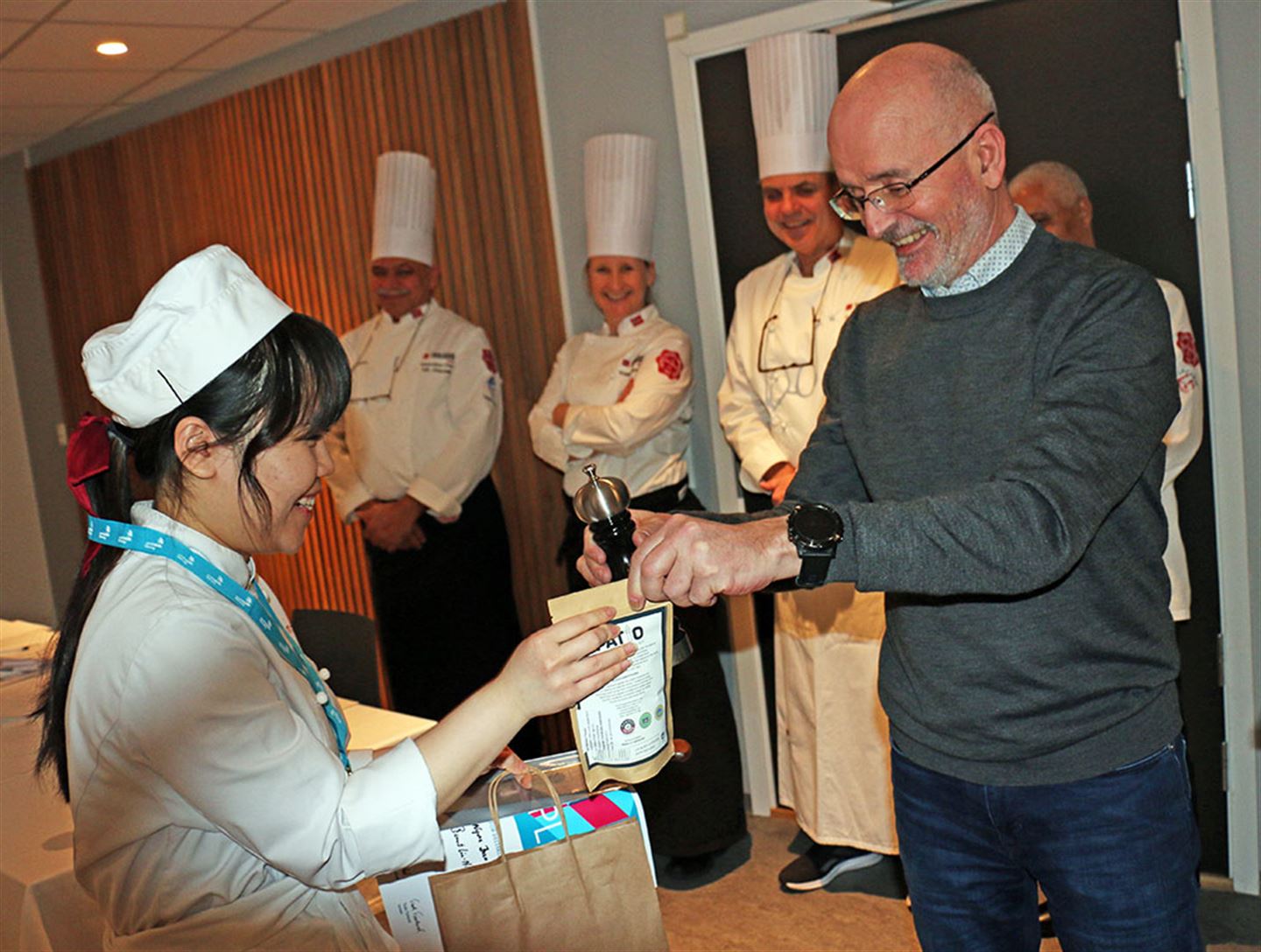 Rektor overleverar premie til kokk. Foto.