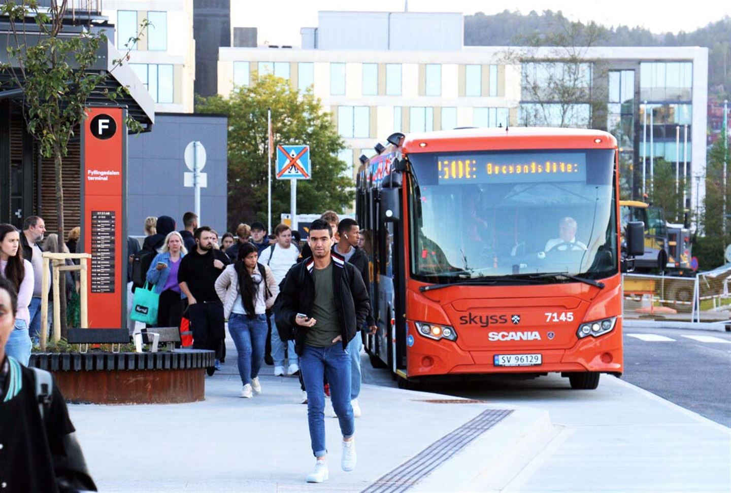 Buss og busspassasjerer på bussterminal.