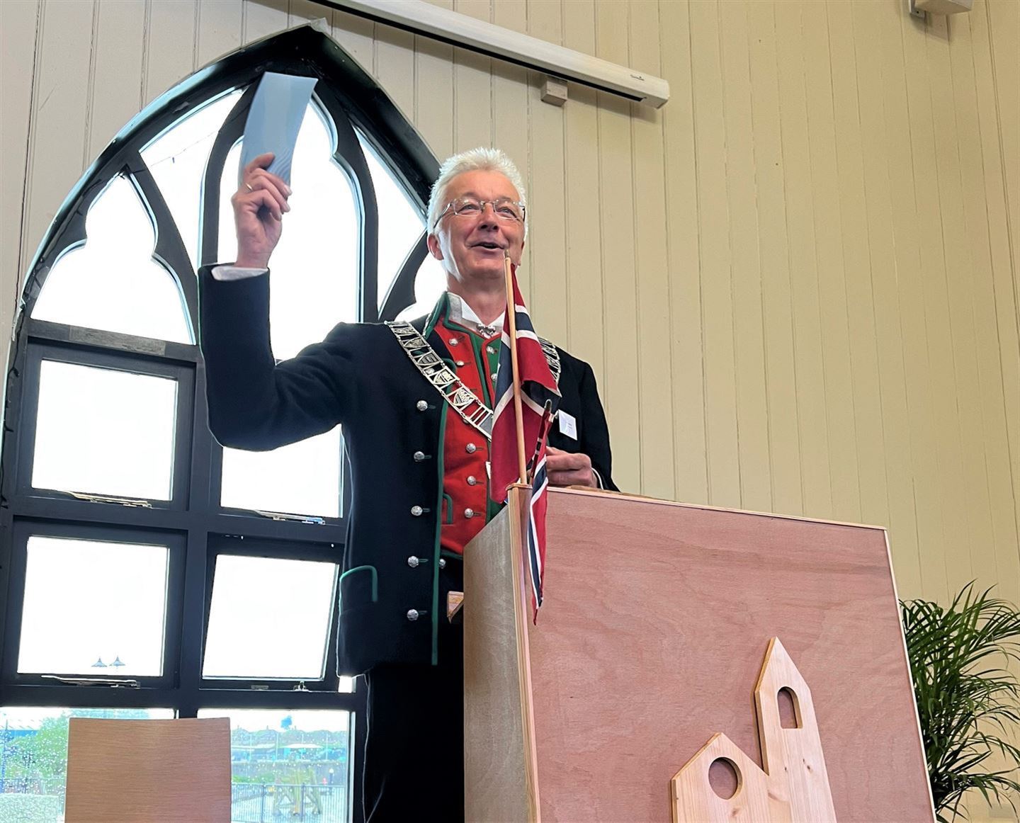 Mann på talarstol i kyrkje