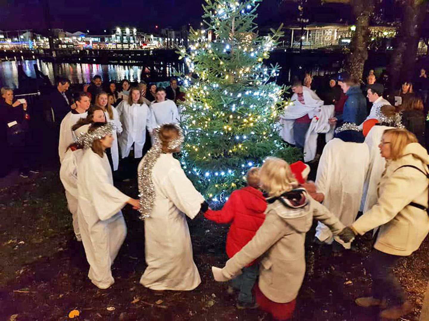 Ungdommar som går rundt juletre.