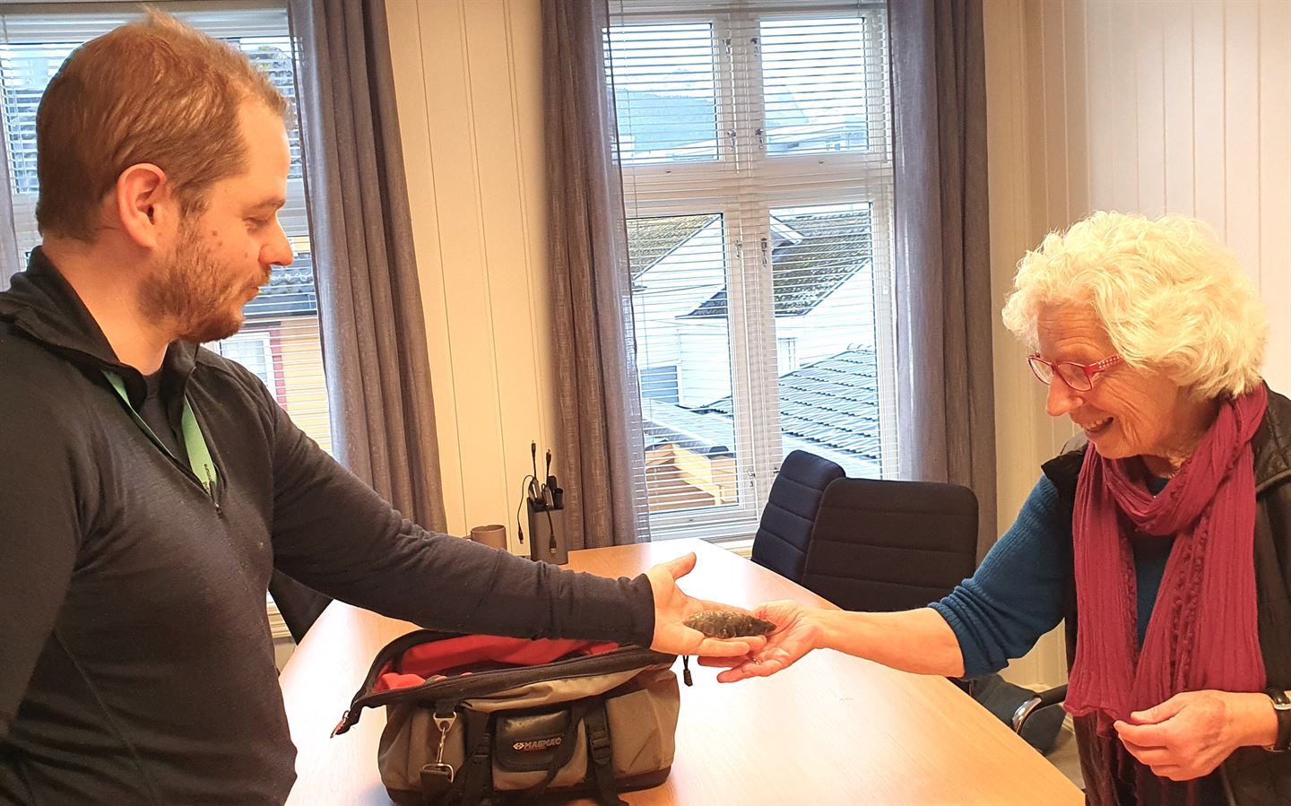 Mann og kvinne held ein liten flintdolk saman.