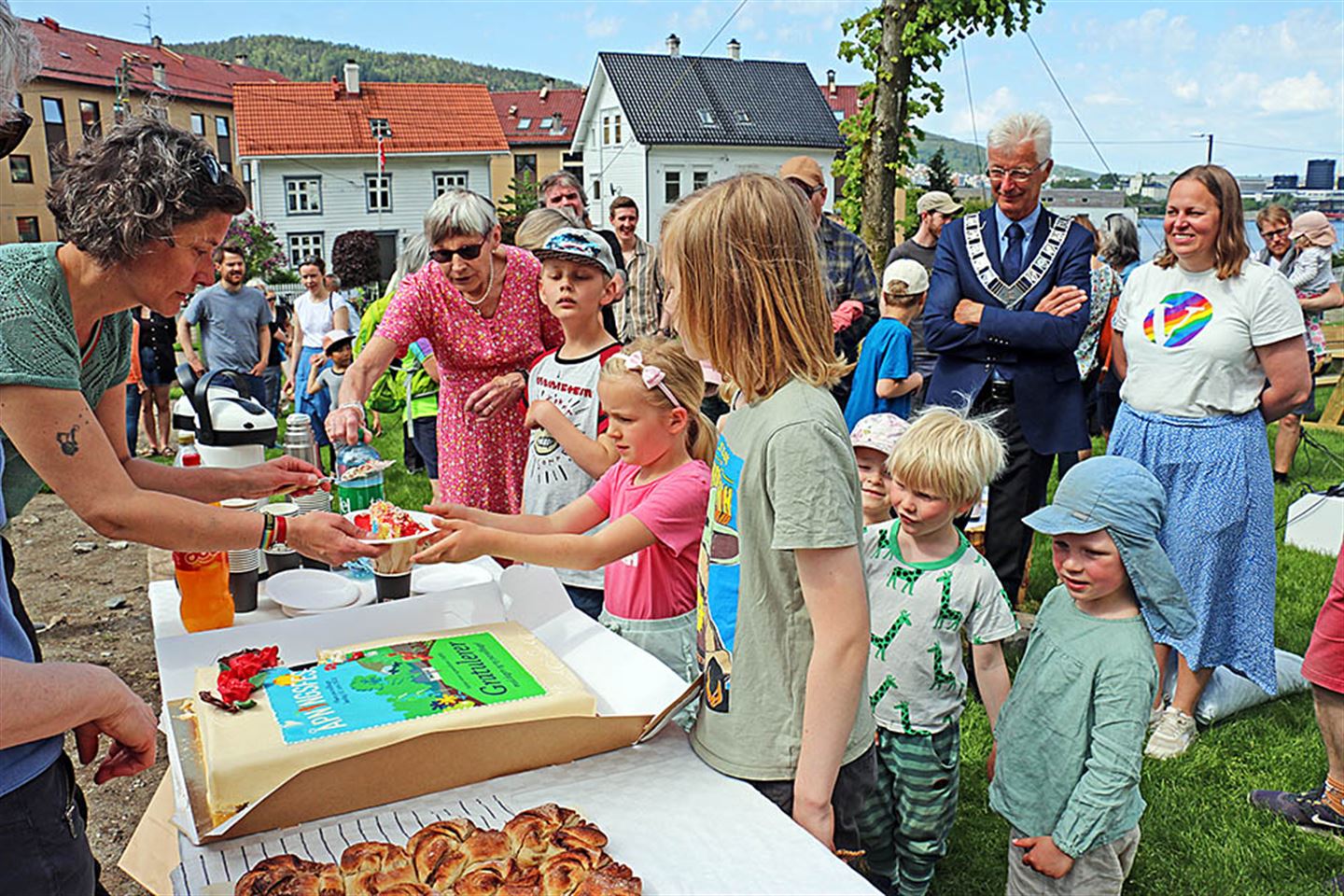 Mange personar som får kake ved eit bord.