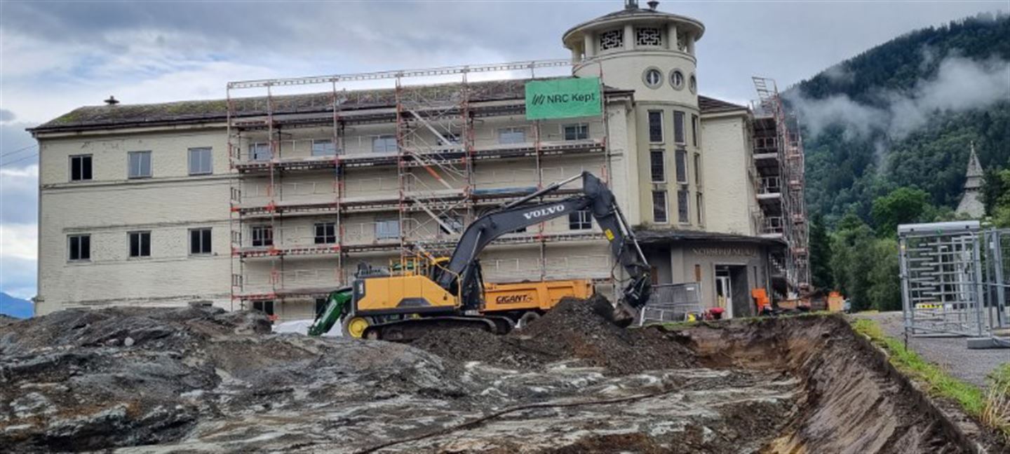 Gravemaskin og byggeplass i Norheimsund, framfor gamleskulen der.