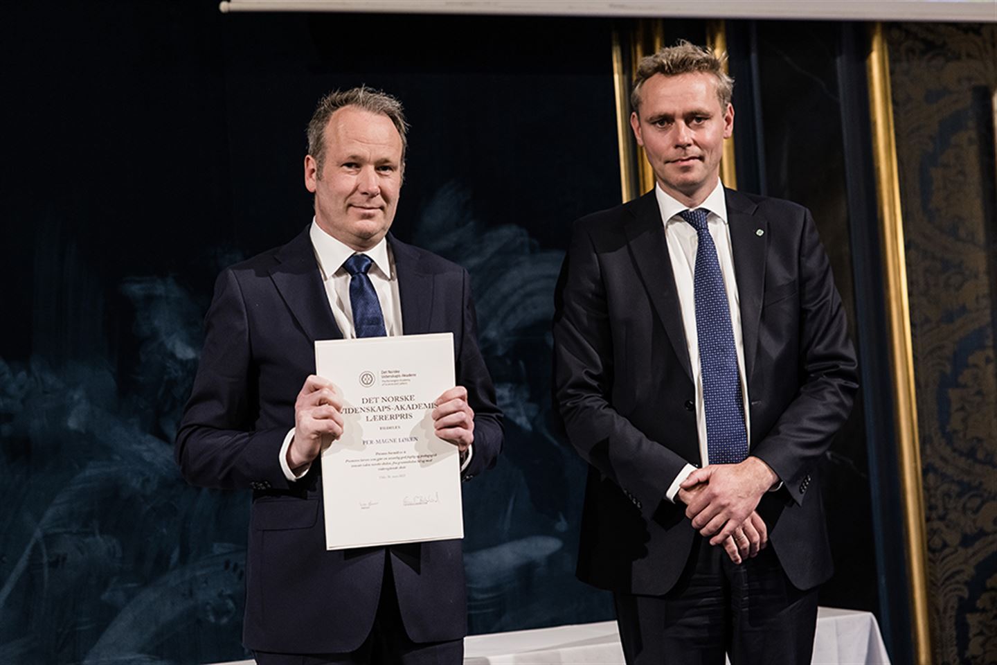 Per-Magne Løken med diplomet han fekk ved utdeling av Det norske videnskaps-Akademiets lærerpris. Statsråd Ola Borten Moe står ved sidan av han.