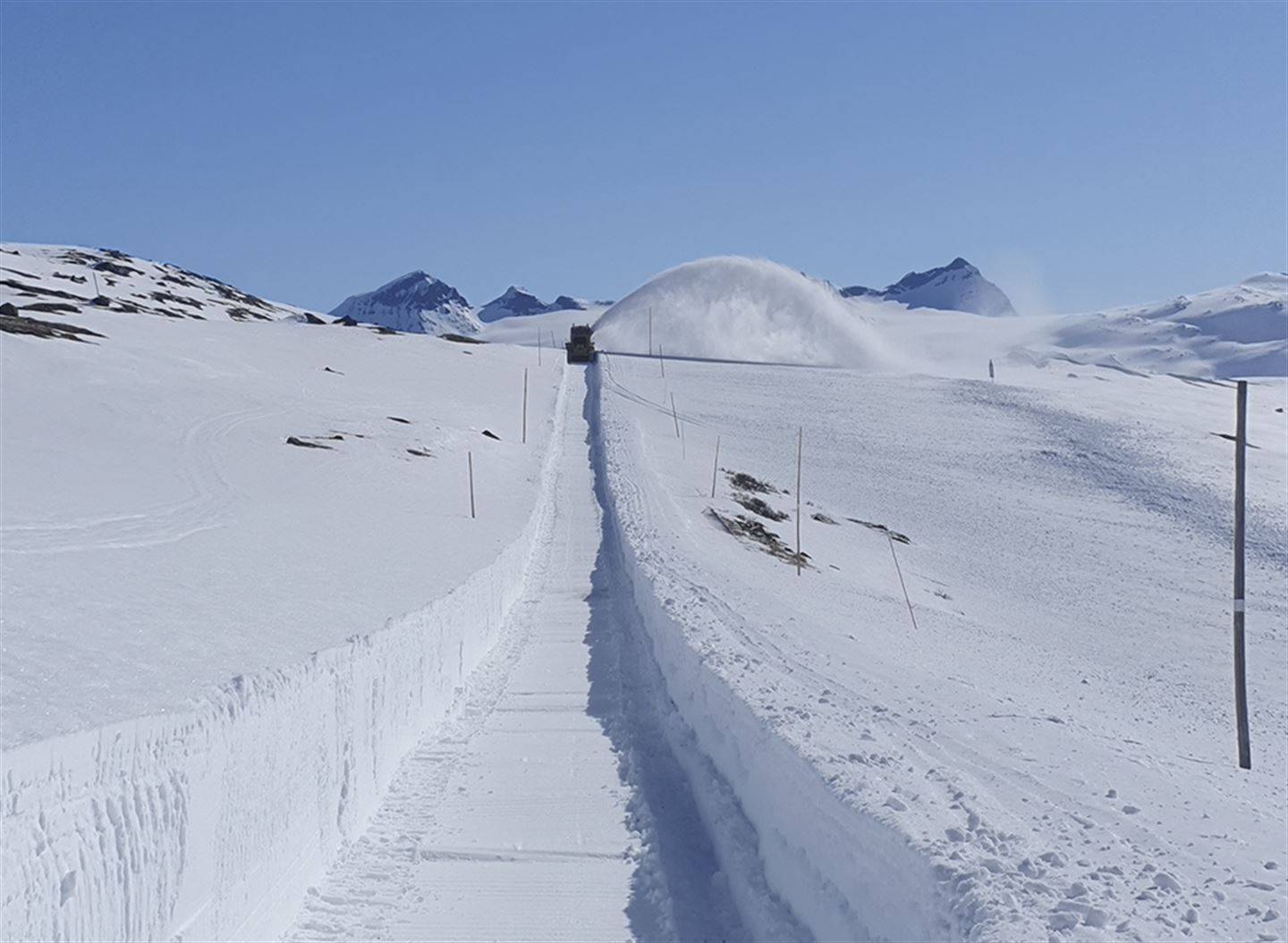 Brøyting av vegen over Sognefjellsvegen. Smørstabbtindane i bakgrunnen.
