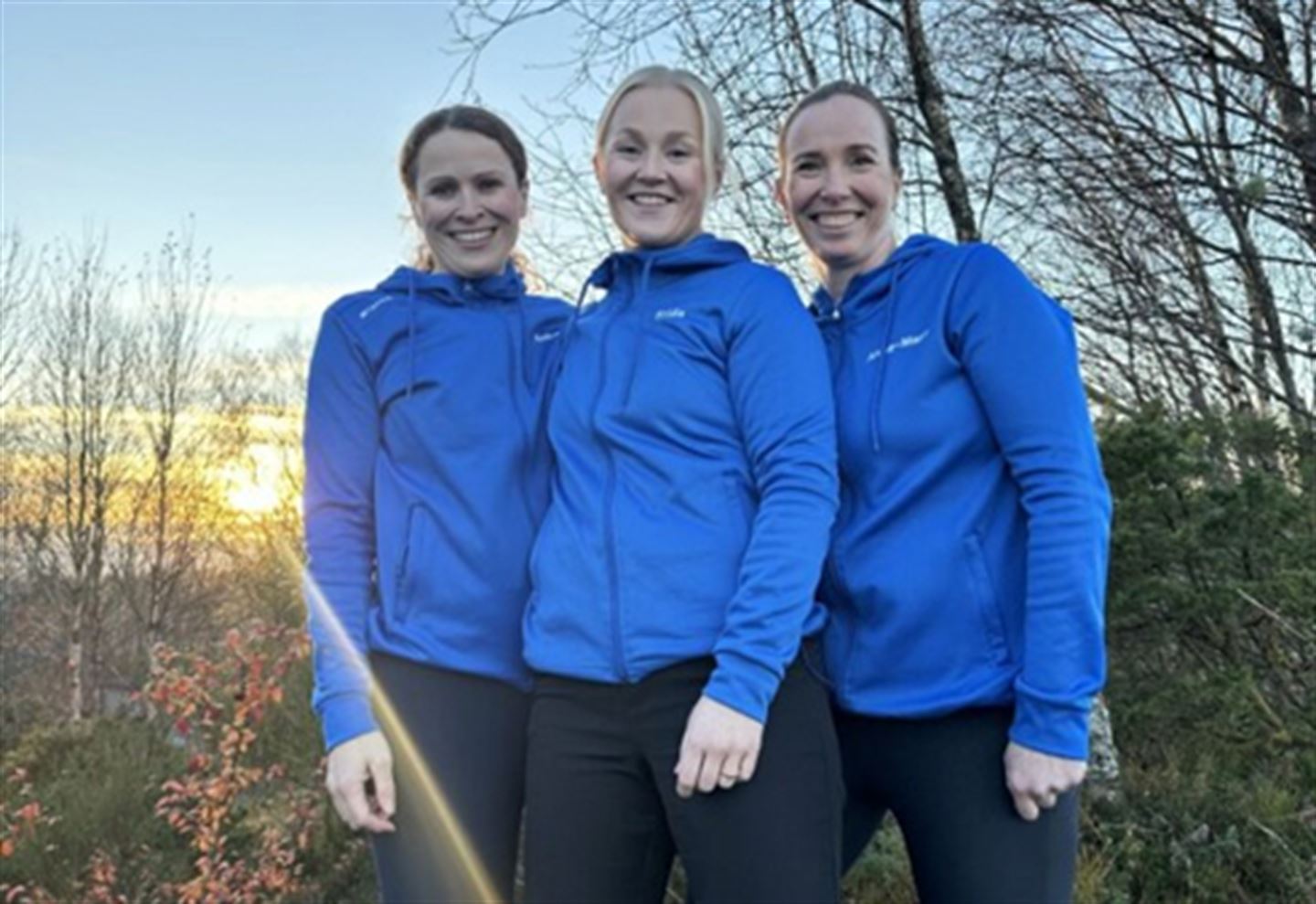 Tre kvinner i blå jakker.