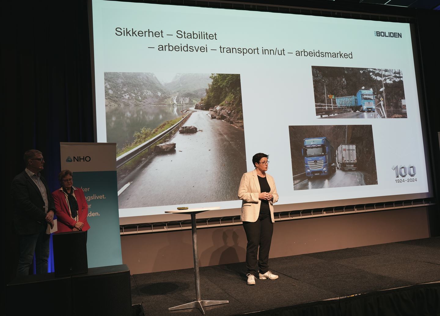 bilde av dame på en scene som holder en presentasjon