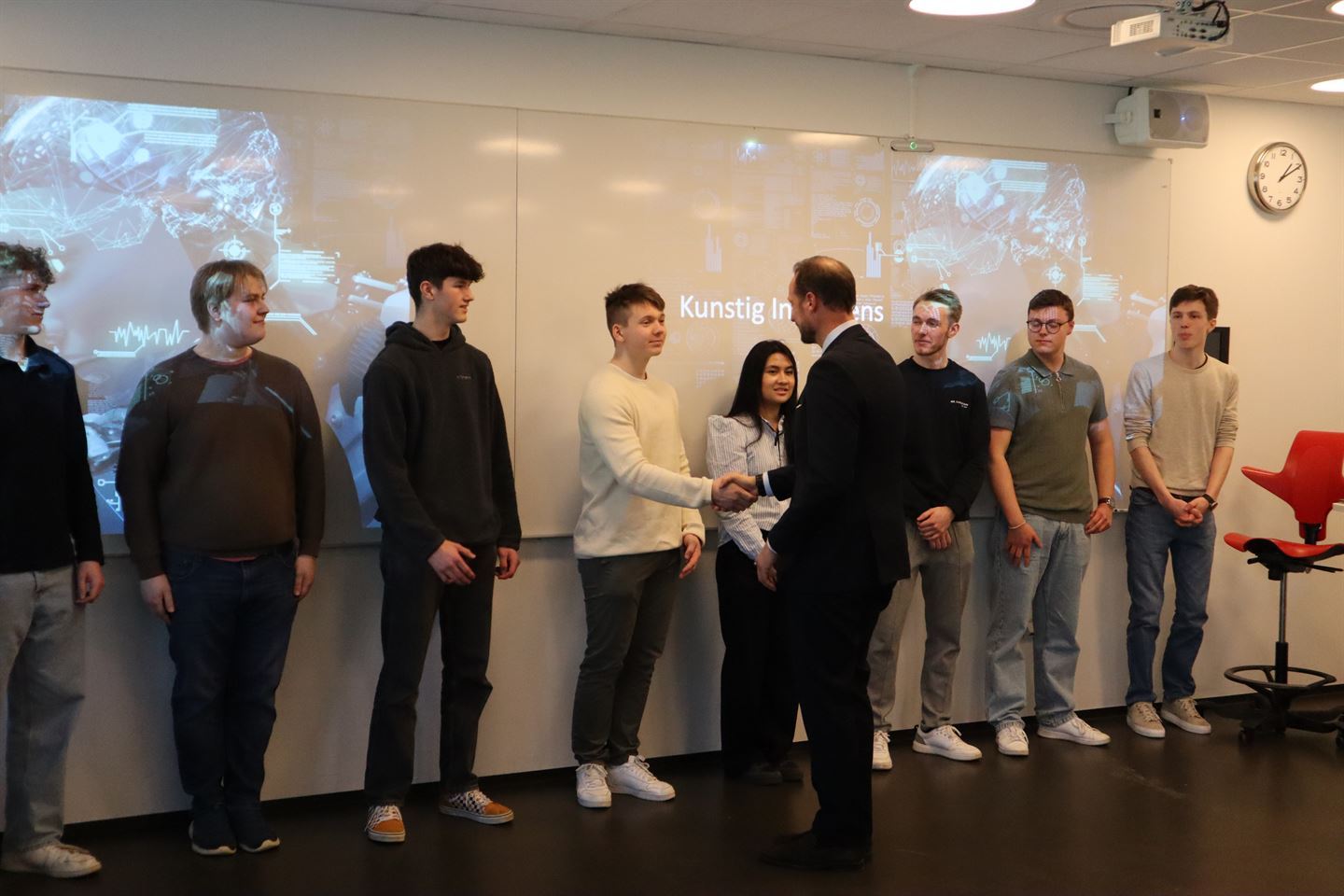 Kronprinsen hilser på elever som står på en rekke.