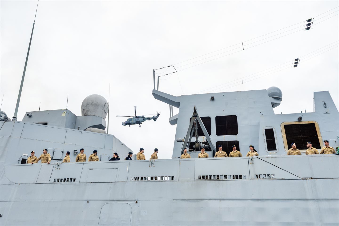 foto av militærbåt, personar og helikopter.