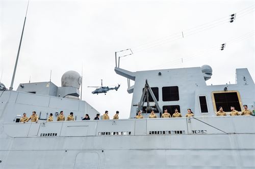 foto av militærbåt, personar og helikopter.
