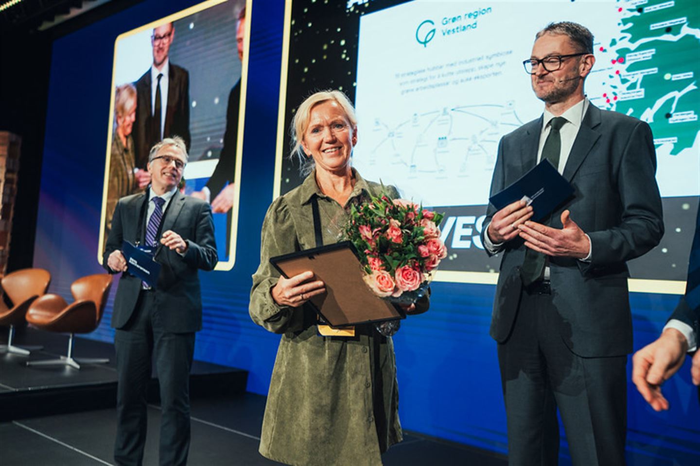 foto av personar som står på ei scene