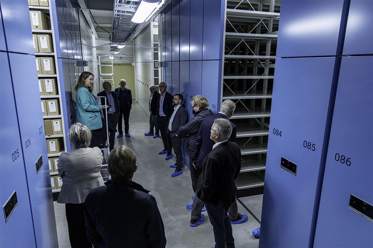 Menneske på omvisning i arkivmagasin.