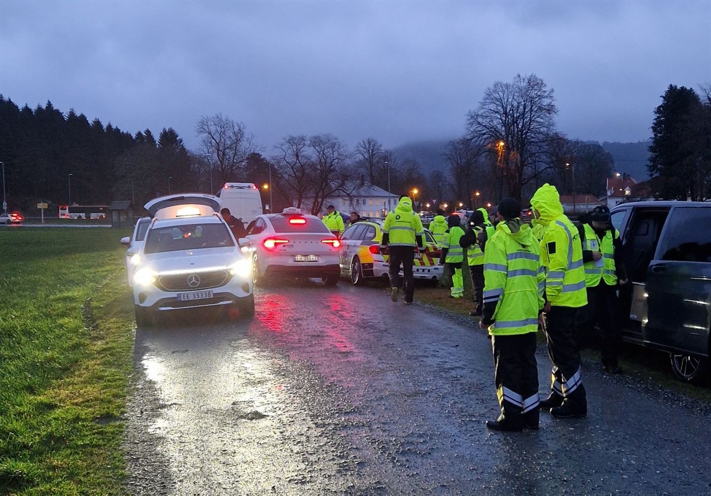 Folk som står ved drosjar som blir kontrollert.