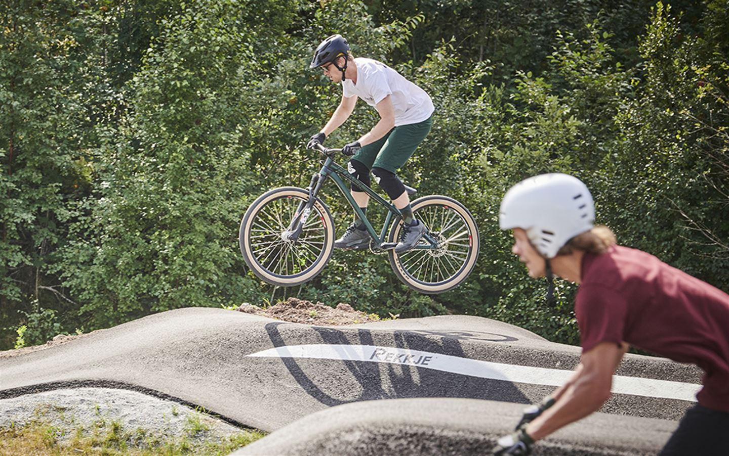 To unge menneske som syklar i pump track.