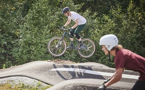 To unge menneske som syklar i pump track.