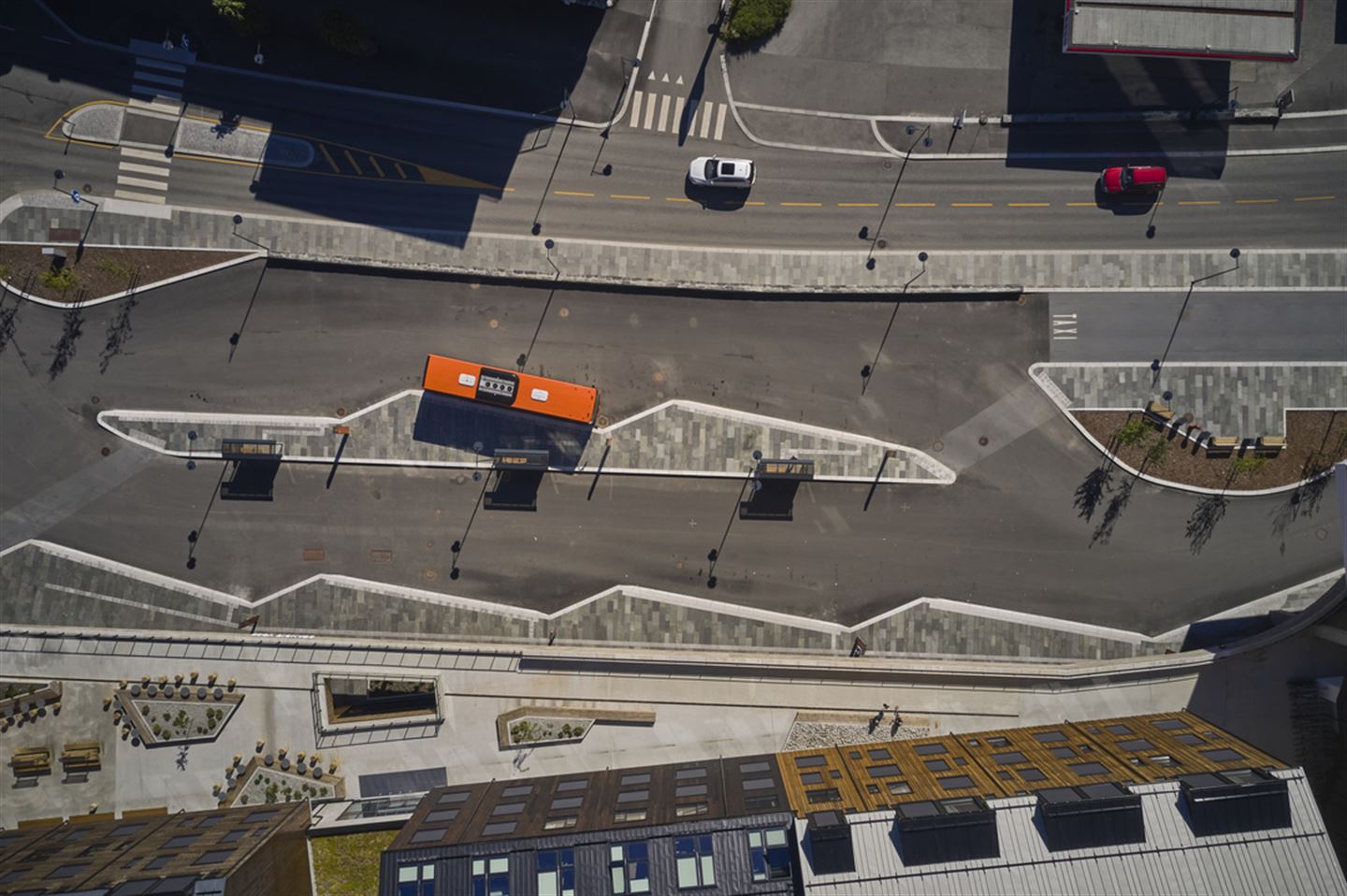 Dronefoto som syner gater, buss og litt av bygg.