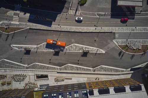 Dronefoto som syner gater, buss og litt av bygg.