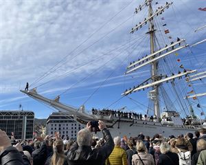 foto av skuta  Statsraad Lehmkuhl  med folk som står på kaien og ser.