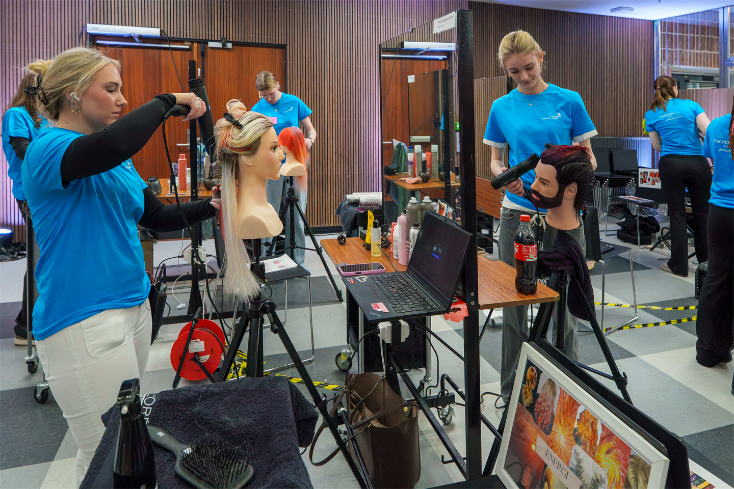 Elev som føner dukke med parykk