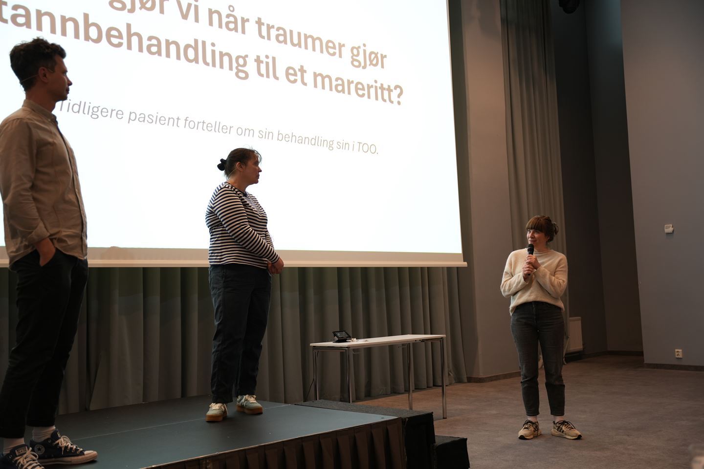 Tre personer på en scene forteller om tannbehandling og traume