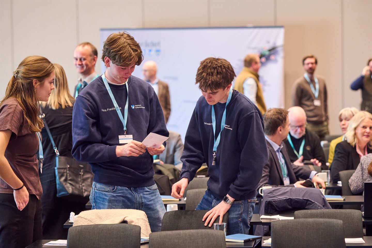 foto av tre unge personar i ein sal