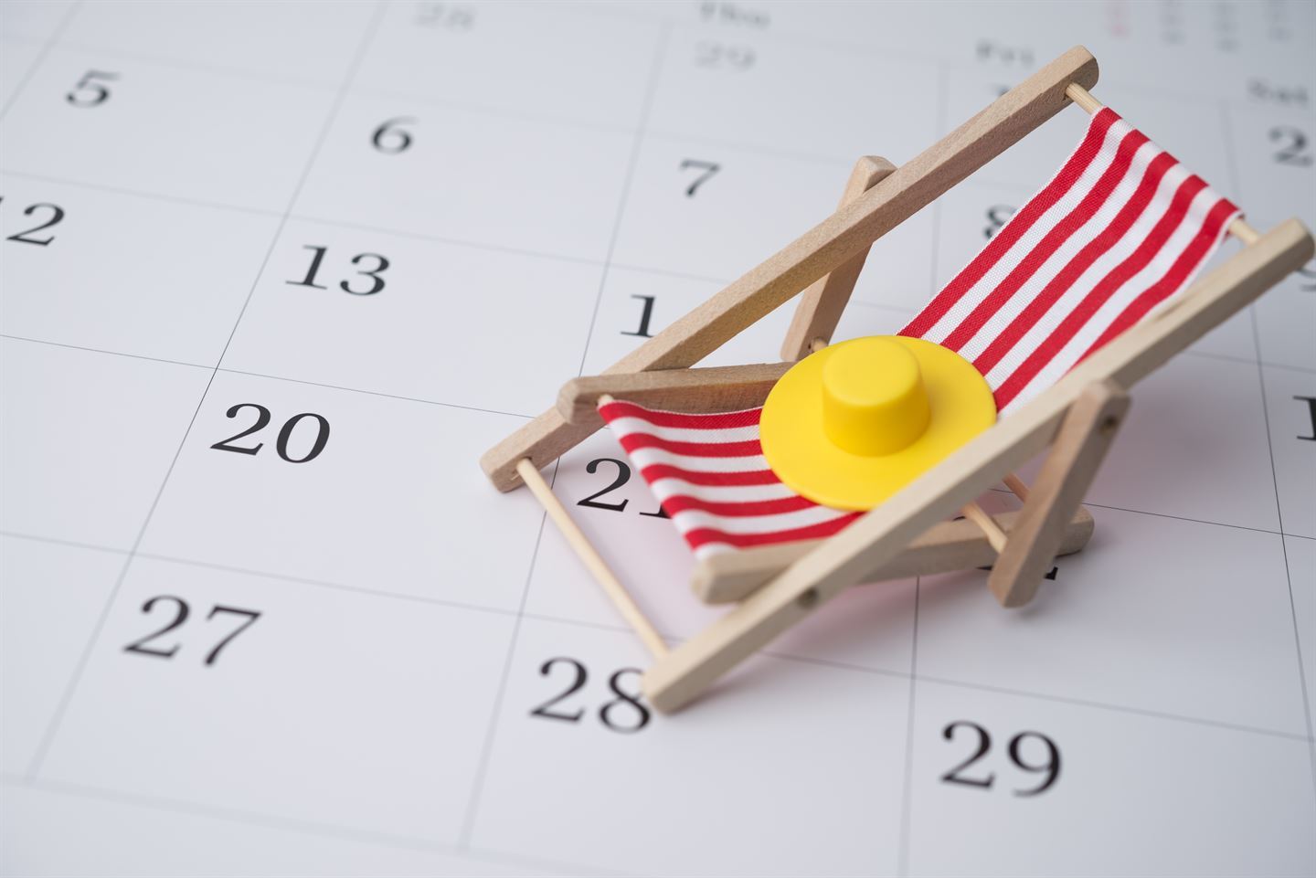 Papirkalender med minisolstol og solhatt oppå.