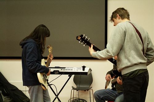 Ungdomar som spelar gitar og andre instrument.