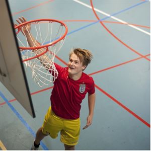 ung basketspelar hoppar opp mot basketkorg