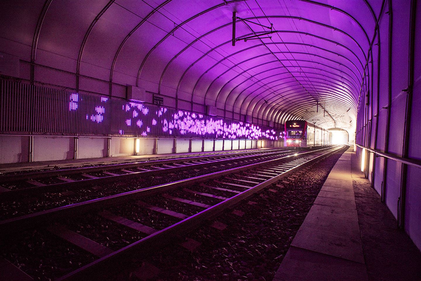 foto av kunstverket Kjankaren langs bybanetraseen. Det er lilla lys på ein tunnelvegg.