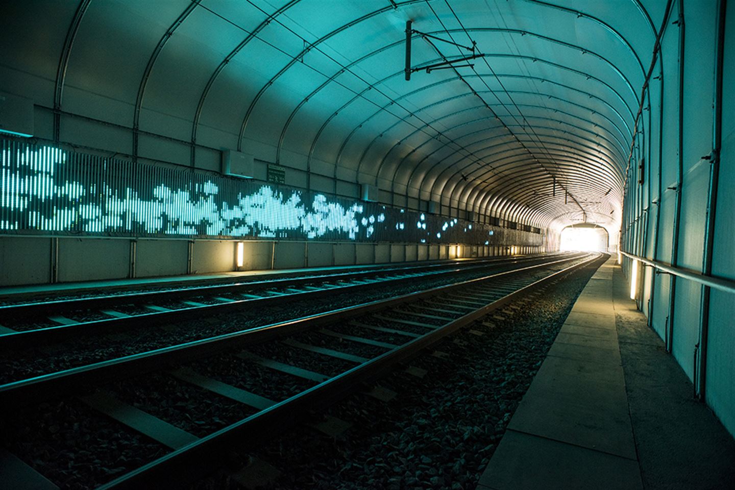 foto av kunstverket Kjankaren langs bybanetraseen. Det er turkis lys på ein tunnelvegg.