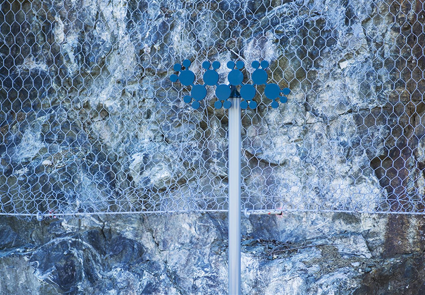 foto av kunstverket Olje-Norge langs bybanetraseen. Det er ein mørkeblå figur festa øvst på ein stolpe.