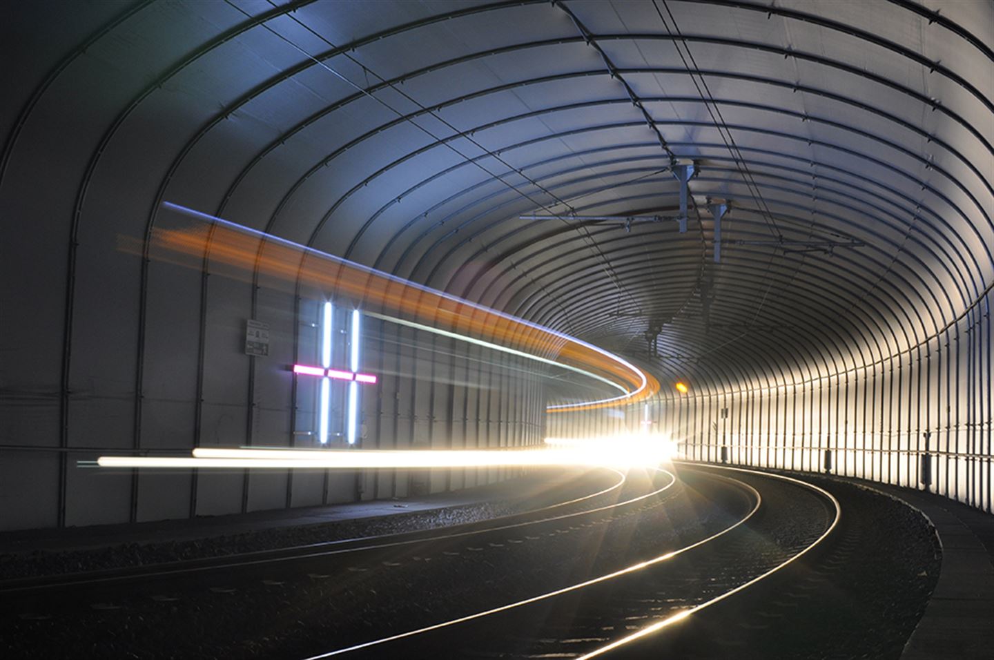 Foto av kunstverket Prime inni ein bybanetunnel. Det er lys i rosa og kvitt.