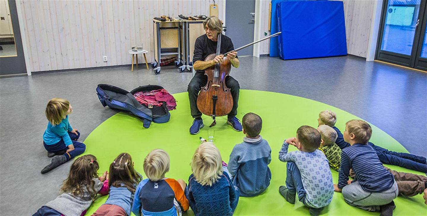 Musikar med strengeinstrument blant barnehagebarn.