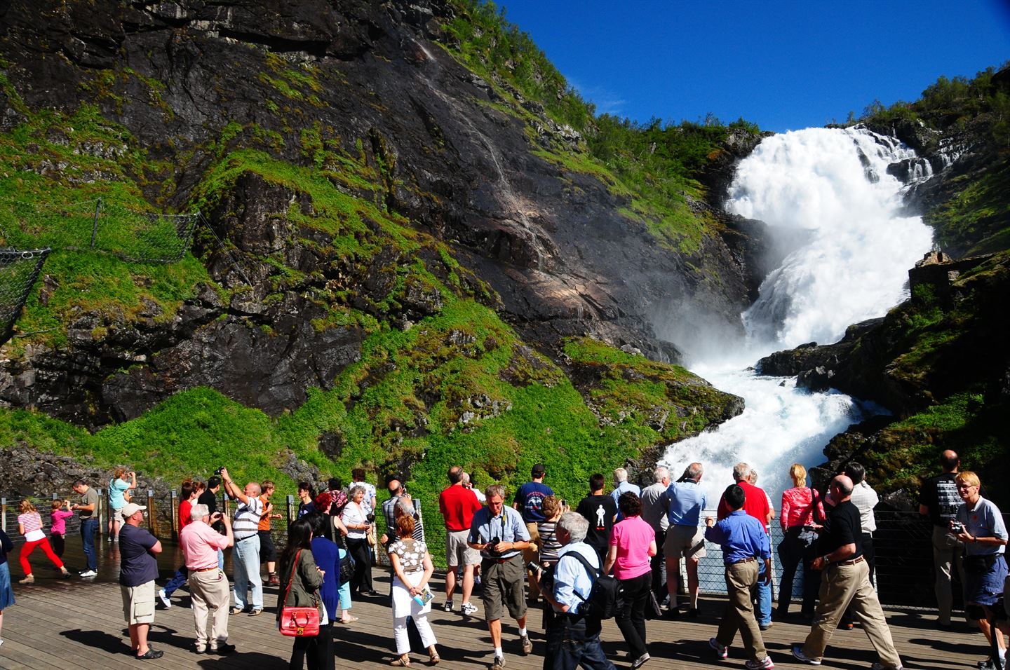 foto av turistar som står ved ein foss