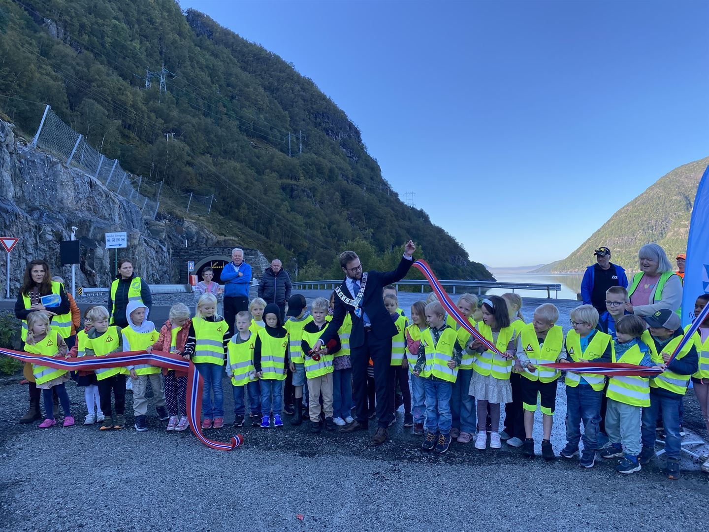 Fleire born som står på rekke og snor som blir klypt.