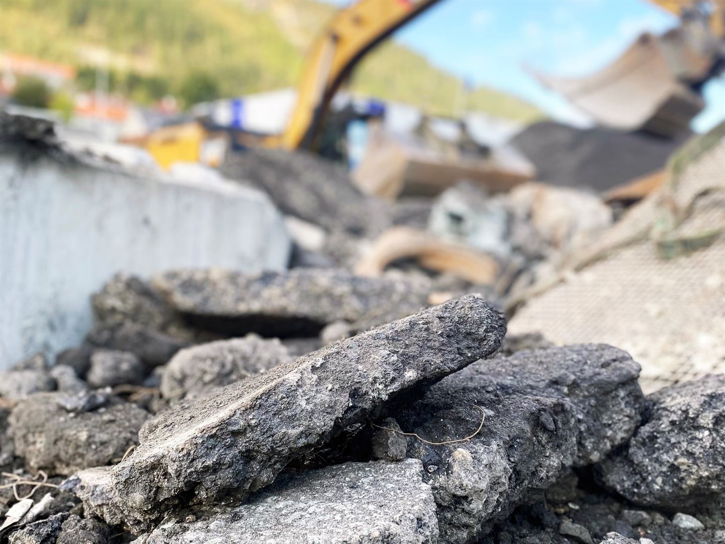 oppstykket asfalt med diffus gravemaskin i bakgrunnen.
