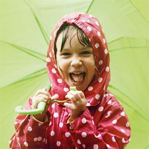 Blid jente i raude regnkle og med grøn paraply.