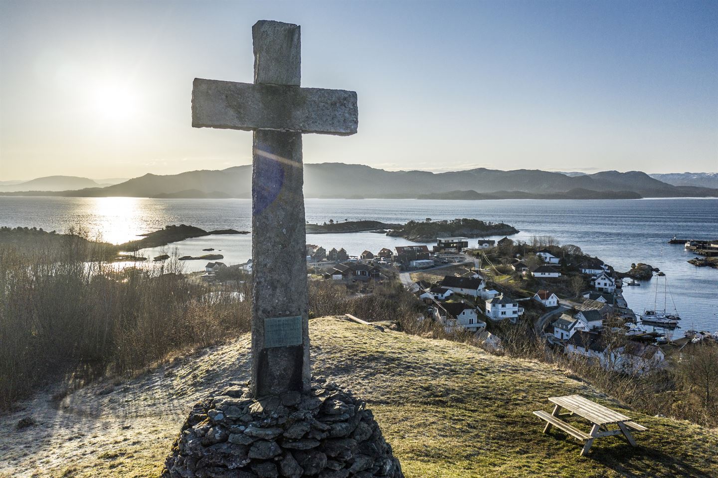 Stort steinkors på toppen av en haug med utsikt over Moster på Bømlo i bakgrunnen.